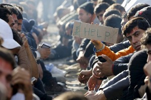 Stranded Iranian migrants sit on rail tracks at the border between Greece and Macedonia near the Greek village of Idomeni
